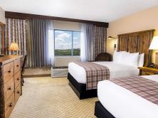 Two Queen beds in room with rustic wood furnishings