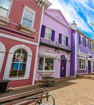 Colorful storefronts and brick walkway at the Brasnon Grand Village Shoppes