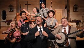 Cast of musicians and singers performing a lively Branson theater production with banjo, fiddle, and vocal harmonies on a classic stage set of Smoke on the Mountain Show.