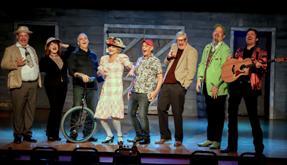 Cast of performers from the Comedy Bash Dinner Show, taking a bow during a lively Branson stage comedy show, featuring music, humor, and audience interaction
