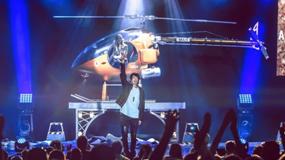 Reza, the Master Illusionist, leading a high-energy stage production with magic, music and dramatic lighting, engaging a cheering audience.