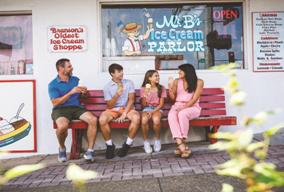 Family sitting on a bench outside a Branson ice cream parlor, enjoying treats and a relaxed downtown atmosphere�an authentic local experience
