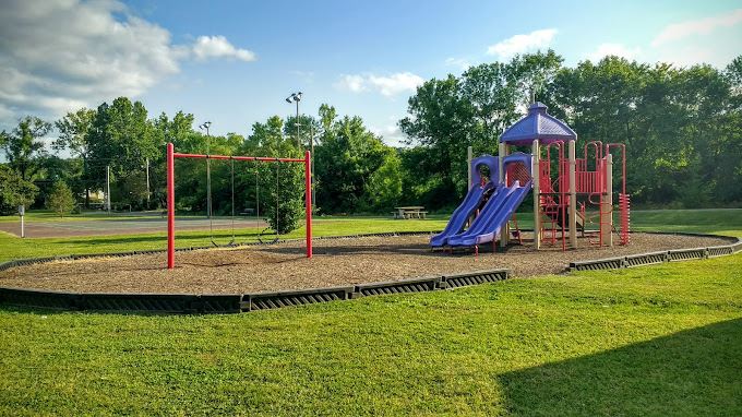 �Colorful outdoor playground with slides and climbing structures surrounded by trees, highlights budget friendly Branson MO recreation for families and children.�