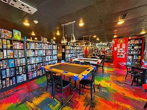 Vibrant indoor board game caf� with colorful flooring, shelves of games, and communal tables, offering unique and budget friendly Branson MO entertainment for all ages.