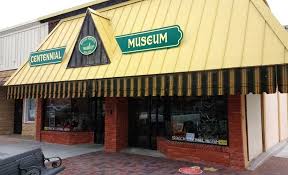 Street-level exterior of a local museum with green awning and brick entrance