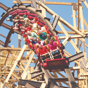 Riders gripping tightly as a wooden roller coaster plunges through a steep curve, framed by classic timber supports�an exciting outdoor attraction often included in Affordable Branson vacation packages.