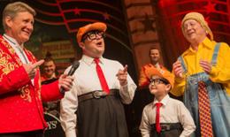 Comedic performers from the Presley's Show  in colorful costumes sharing a lively moment on stage, engaging the audience with classic humor and music